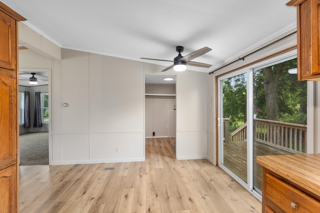 unfurnished room featuring ceiling fan, crown molding, and light hardwood / wood-style floors