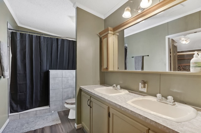 bathroom featuring toilet, a textured ceiling, ornamental molding, vanity, and hardwood / wood-style flooring