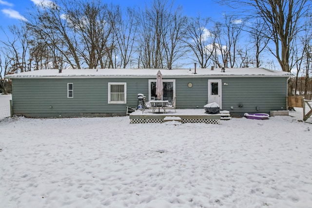 snow covered house featuring a deck