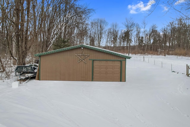 snow covered structure with a garage