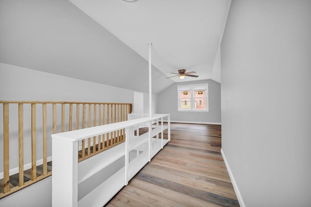 hall featuring light wood-type flooring and vaulted ceiling