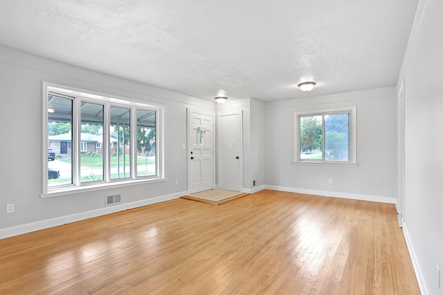 interior space with light hardwood / wood-style floors and a textured ceiling