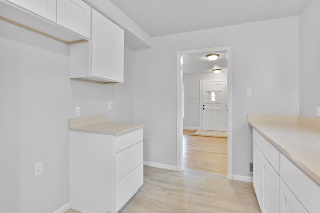 kitchen with light hardwood / wood-style floors and white cabinets