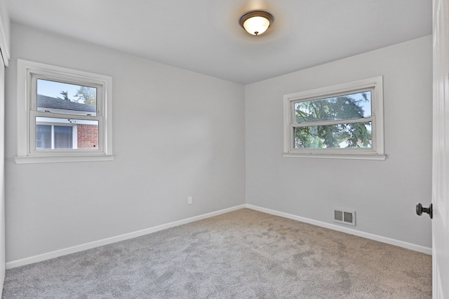 unfurnished room featuring light carpet