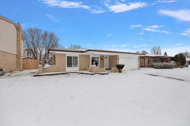 snow covered back of property with a garage