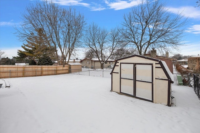 yard layered in snow featuring a storage shed