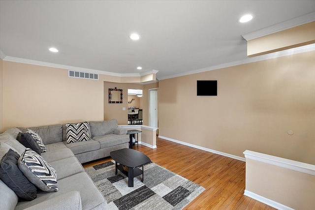 living room with ornamental molding and light hardwood / wood-style floors