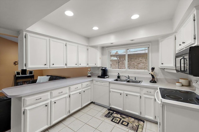 kitchen featuring sink, white appliances, light tile patterned floors, white cabinets, and kitchen peninsula