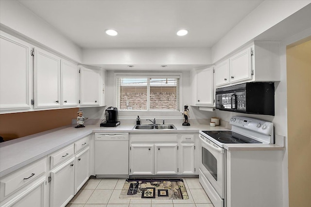 kitchen featuring white cabinetry, sink, light tile patterned floors, and white appliances