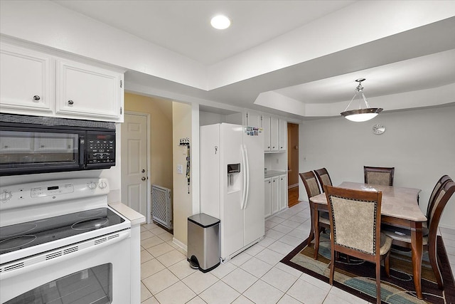 kitchen with light tile patterned flooring, pendant lighting, white cabinets, a tray ceiling, and white appliances