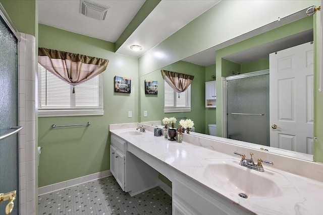 bathroom with vanity, a shower with shower door, and toilet