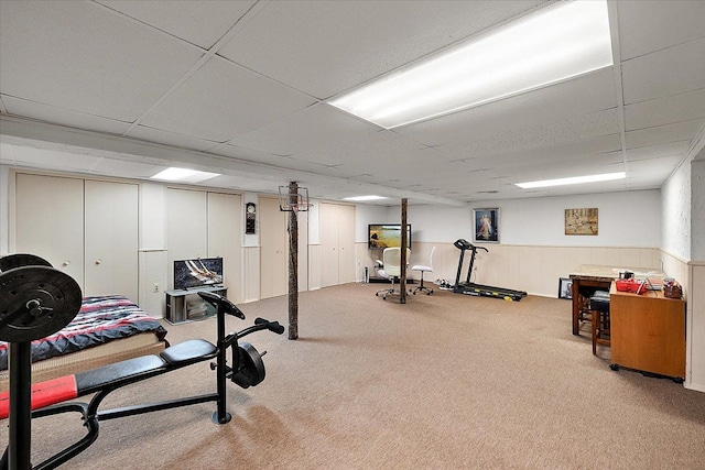 exercise area featuring carpet floors and a paneled ceiling