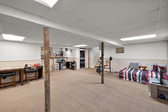 basement with carpet and a paneled ceiling