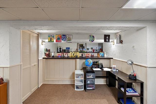 interior space with carpet floors and a paneled ceiling