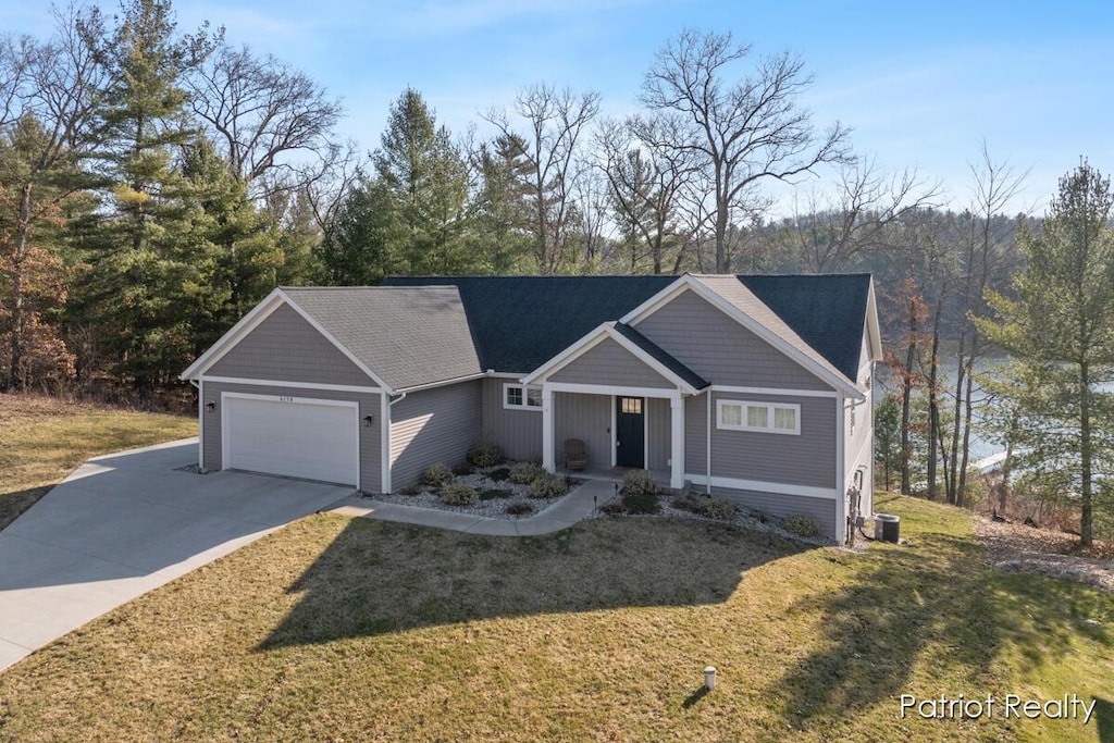 5179 E Manitou Way, Newaygo, MI 49337 - view of front facade featuring a front lawn, driveway, an attached garage, and central AC unit