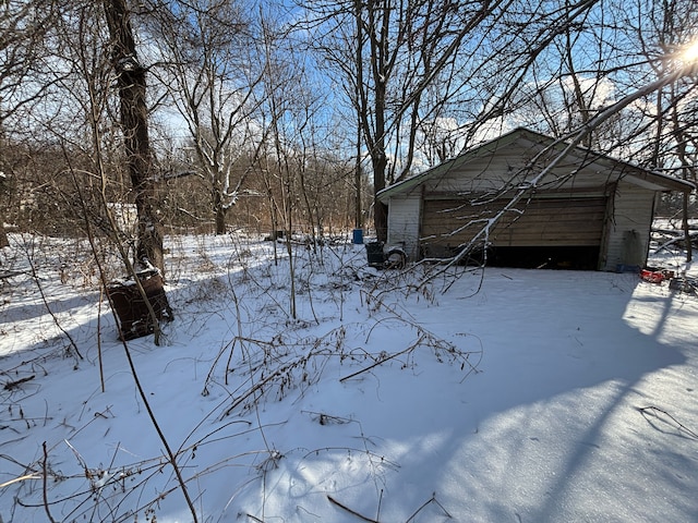 yard covered in snow with a garage and an outbuilding