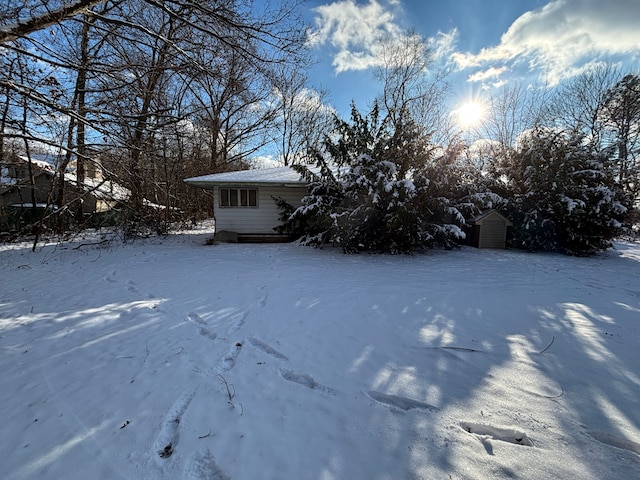 snowy yard with a storage shed