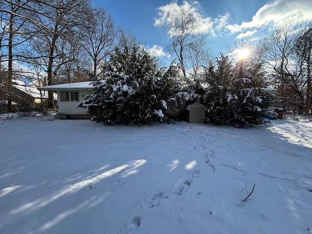 yard layered in snow with a storage shed