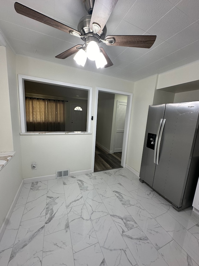 interior space featuring ceiling fan and stainless steel fridge