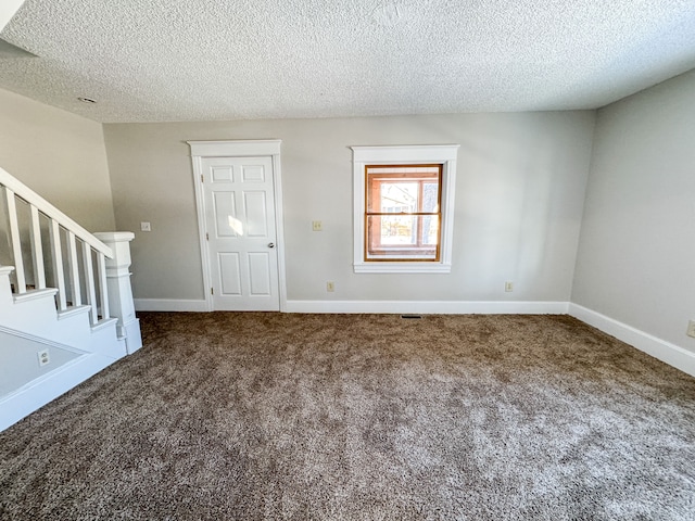 carpeted foyer with a textured ceiling