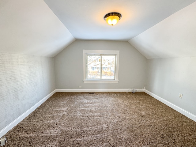 bonus room with lofted ceiling and carpet flooring