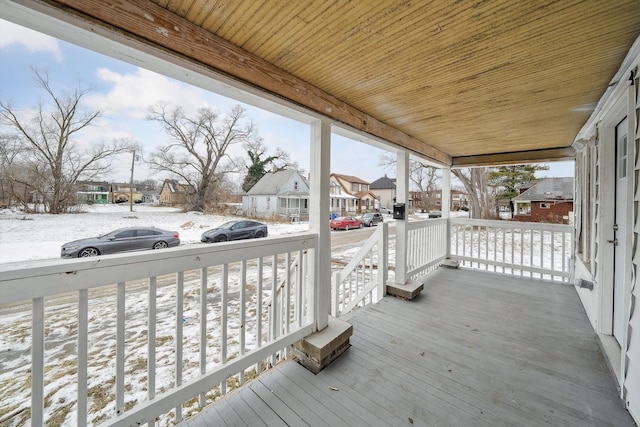 snow covered deck with a porch