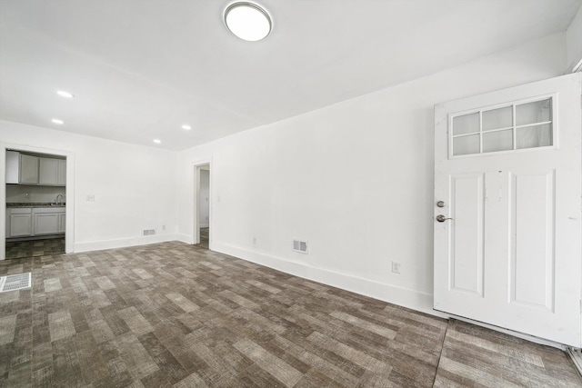 unfurnished living room with sink and hardwood / wood-style floors