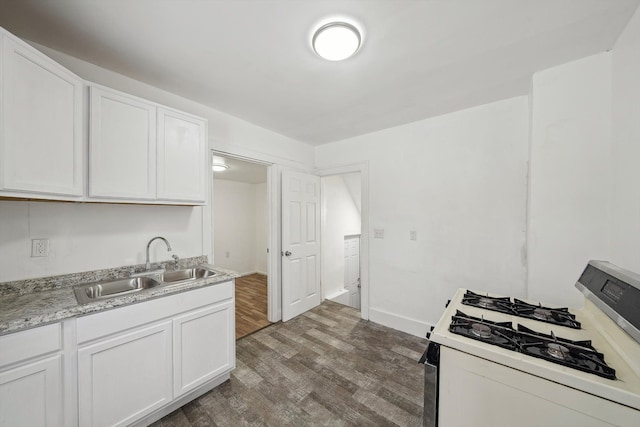 kitchen featuring sink, white cabinetry, dark hardwood / wood-style flooring, and range with gas stovetop