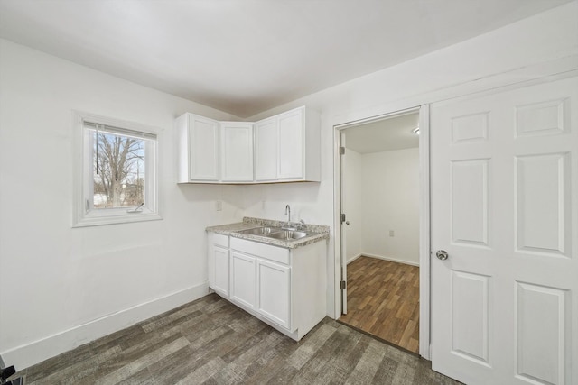 kitchen with dark hardwood / wood-style floors, white cabinets, and sink