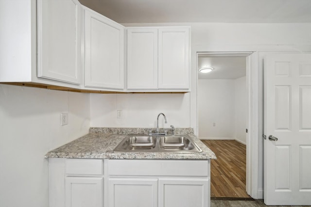 kitchen featuring white cabinetry, dark hardwood / wood-style flooring, and sink