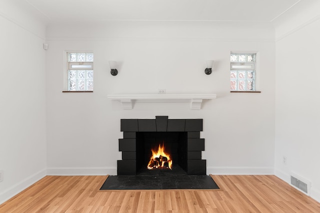 room details featuring wood-type flooring and a tiled fireplace