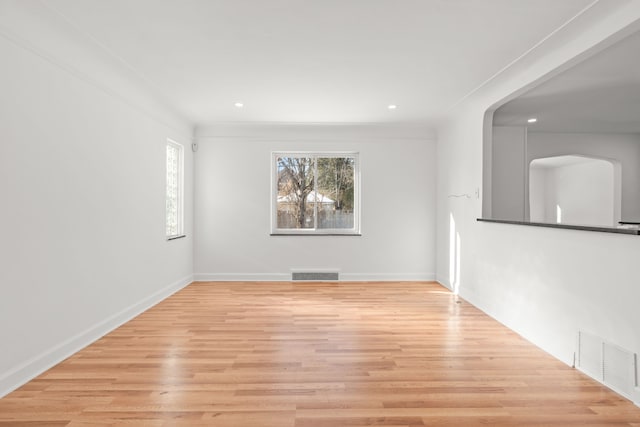 spare room featuring ornamental molding and light hardwood / wood-style floors