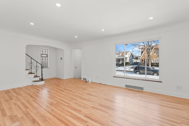 unfurnished living room featuring crown molding and light hardwood / wood-style floors