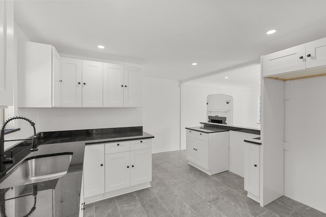 kitchen with white cabinets, sink, and crown molding