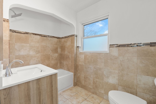 full bathroom featuring toilet, vanity, tile patterned flooring, tile walls, and bathtub / shower combination