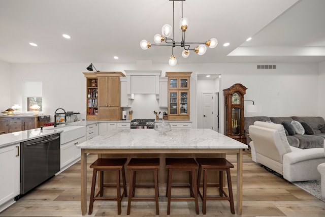 kitchen with white cabinets, dishwasher, and a center island