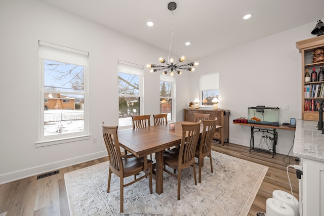 dining area with an inviting chandelier and light wood-type flooring