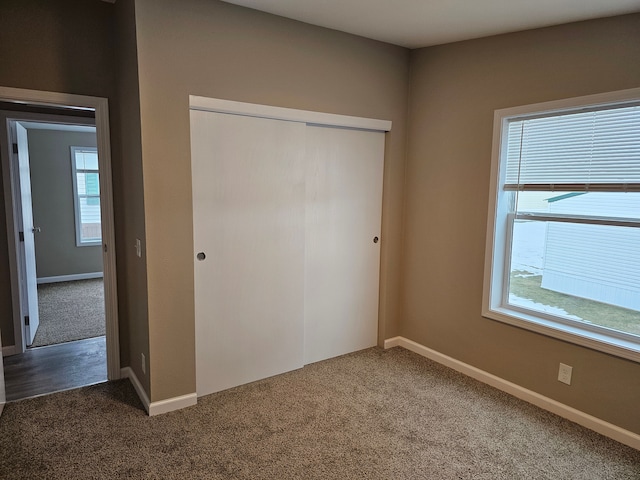 unfurnished bedroom featuring a closet and dark colored carpet