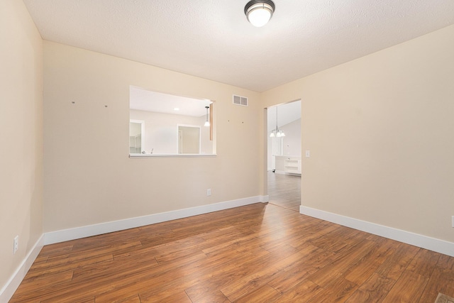 unfurnished room with lofted ceiling and wood-type flooring