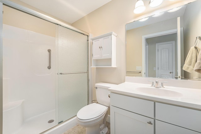bathroom featuring toilet, vanity, and a shower with door