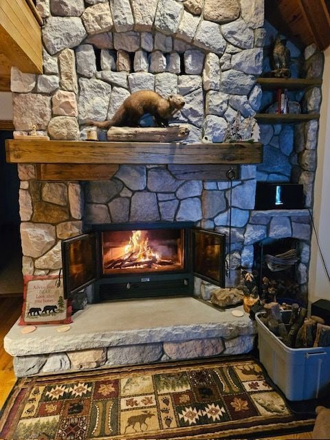 room details with a stone fireplace and hardwood / wood-style flooring