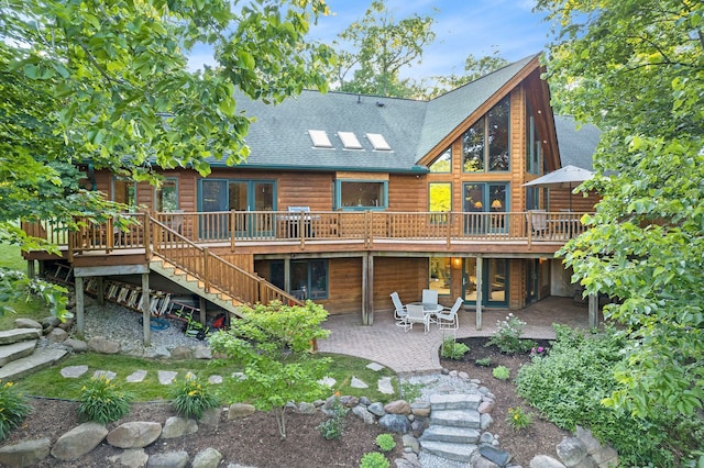 back of property with a wooden deck and a patio area