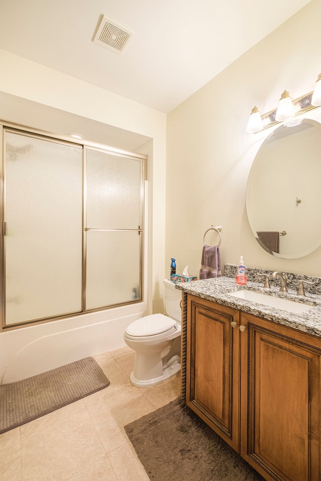 full bathroom featuring tile patterned flooring, vanity, combined bath / shower with glass door, and toilet