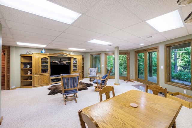 carpeted dining room with a paneled ceiling