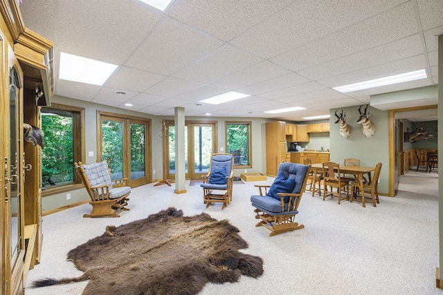 living room featuring a paneled ceiling and light carpet