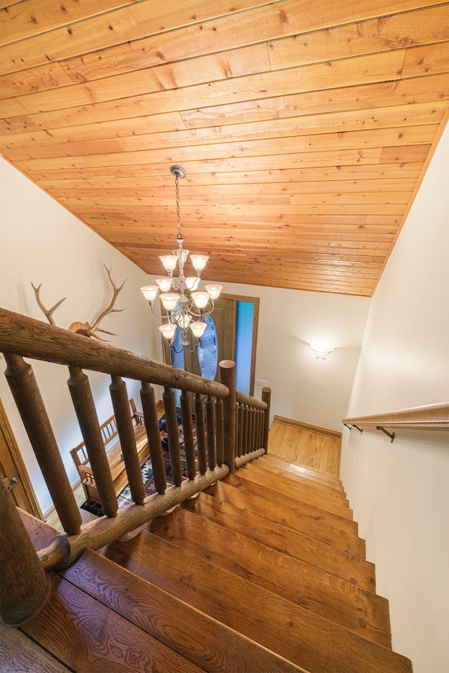 stairway featuring hardwood / wood-style flooring, lofted ceiling, a chandelier, and wood ceiling