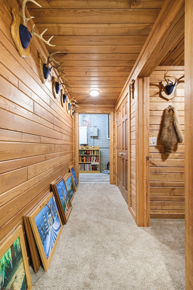 hallway with wood walls, carpet flooring, and wood ceiling