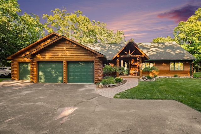 log cabin featuring a lawn and a garage