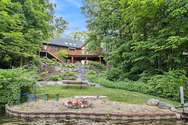 view of yard with a deck and a fire pit