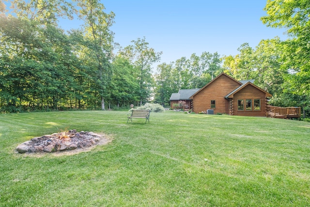 view of yard with a deck and a fire pit